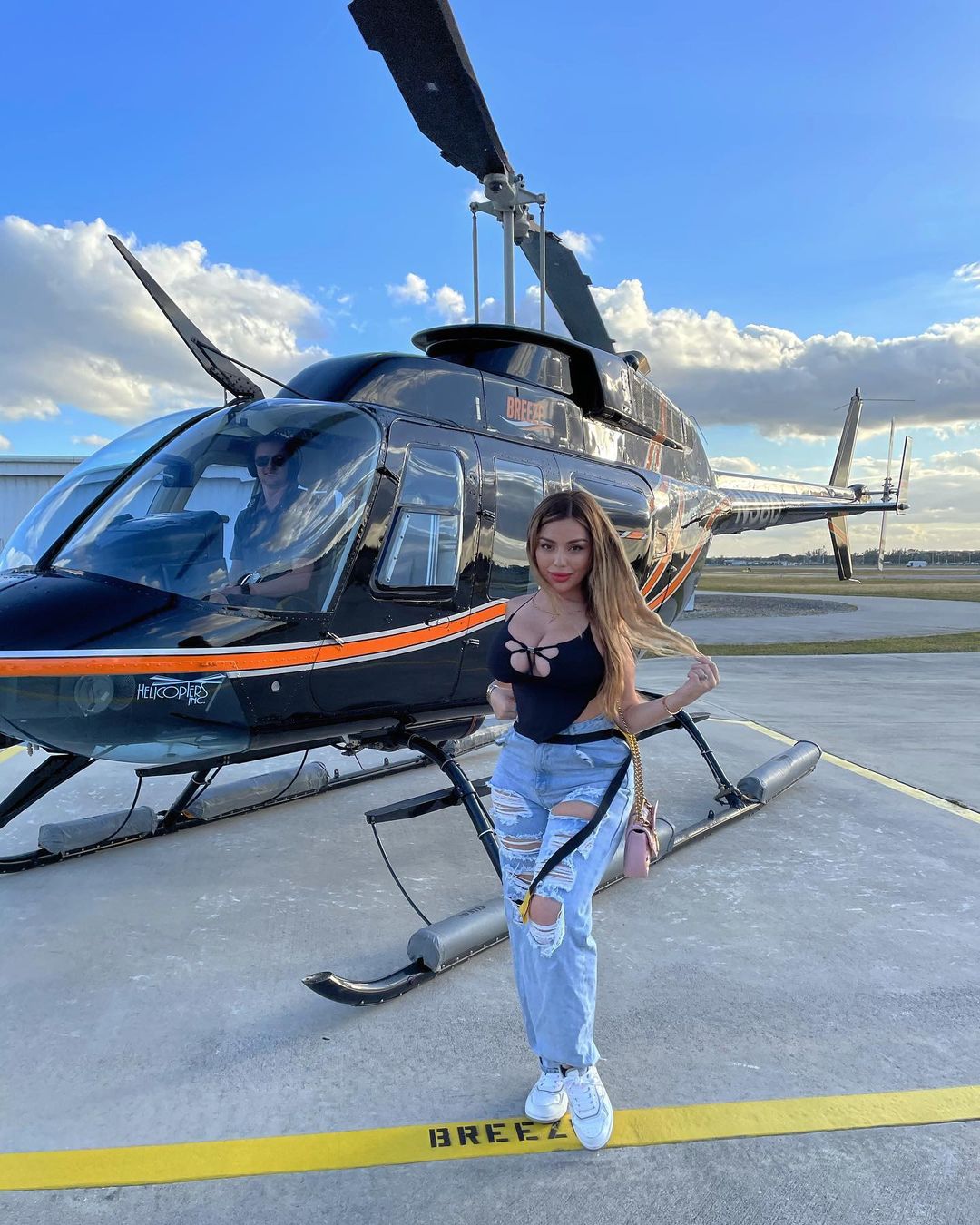 Katiana Kay posing with a helicopter