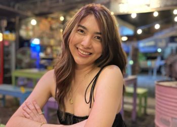 Pau Fajardo with folded hands in black one piece dress