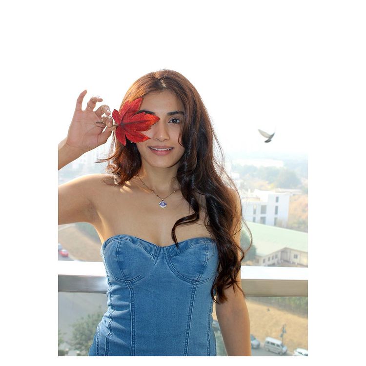 Divya in blue dress with a leaf in her hand