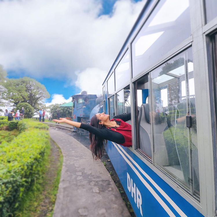 Prerna sticking her head out of a hill station train