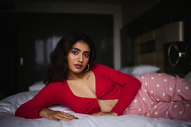 Priya Prakash lying on bed with red crop top on