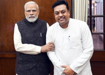 Sambit Patra standing next to the PM of India.