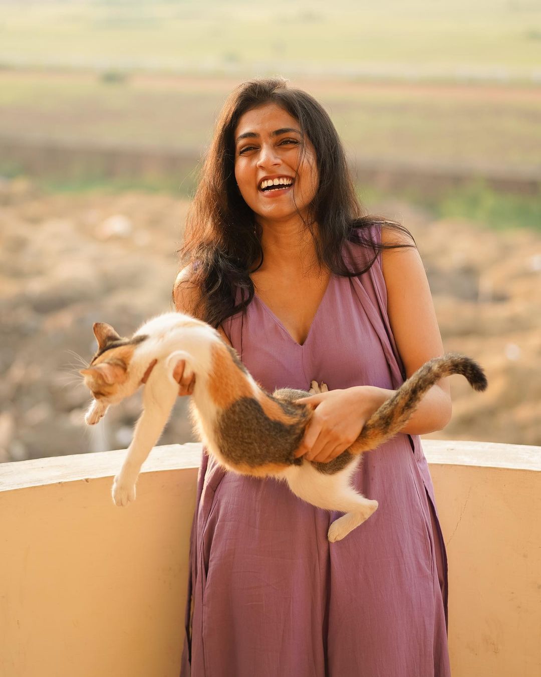 Zarin laughing with her cat in her arms.