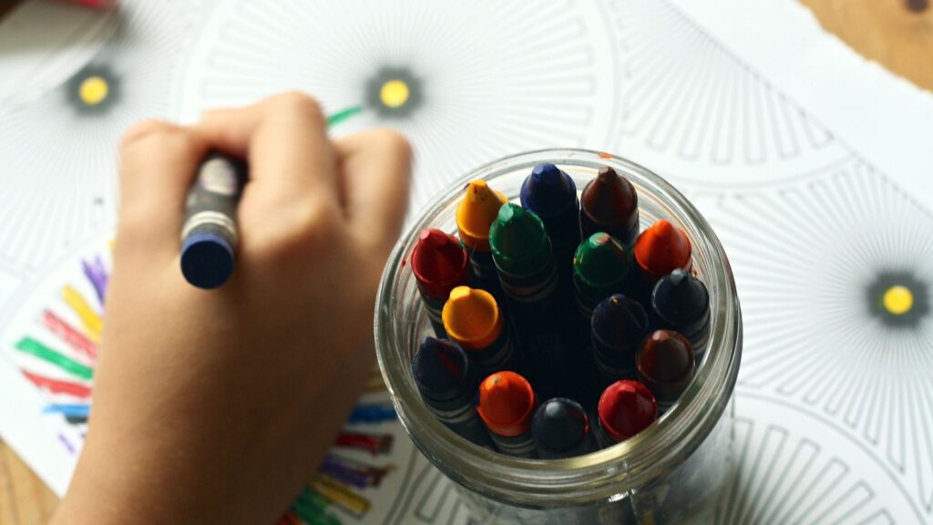 A kid drawing with a crayons