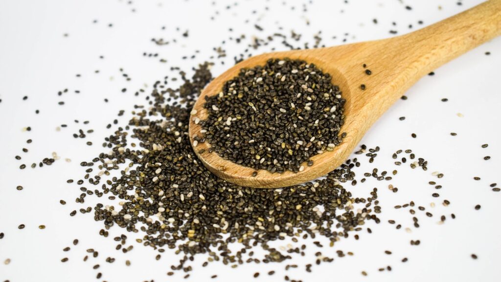 Chia seeds fell out of a wooden spoon on the table