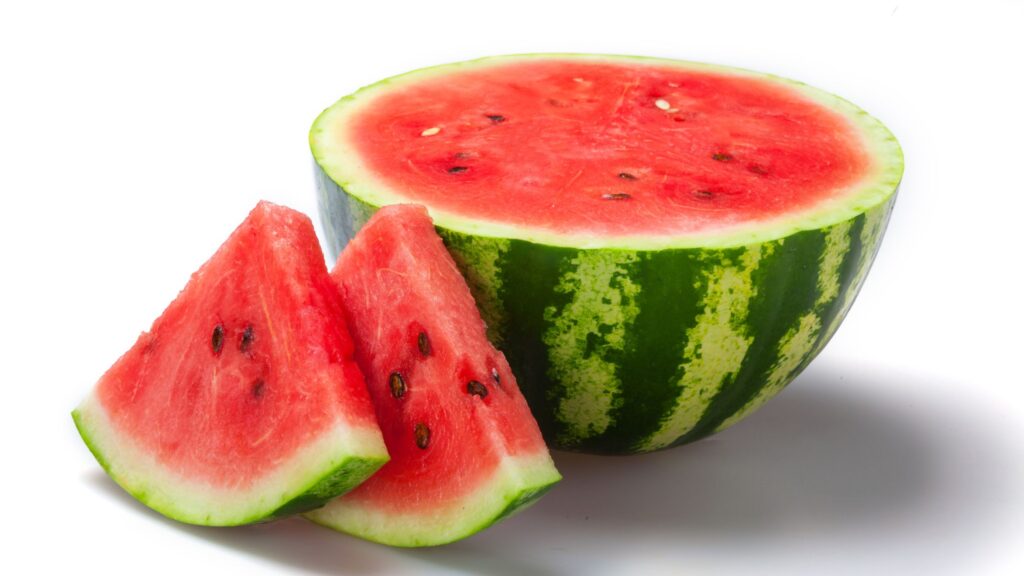 A half cut watermelon and two big slices are places with a white colored background.