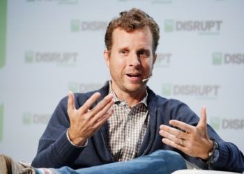 Jamie Siminoff wearing white check and blue jacket speaking in an event.