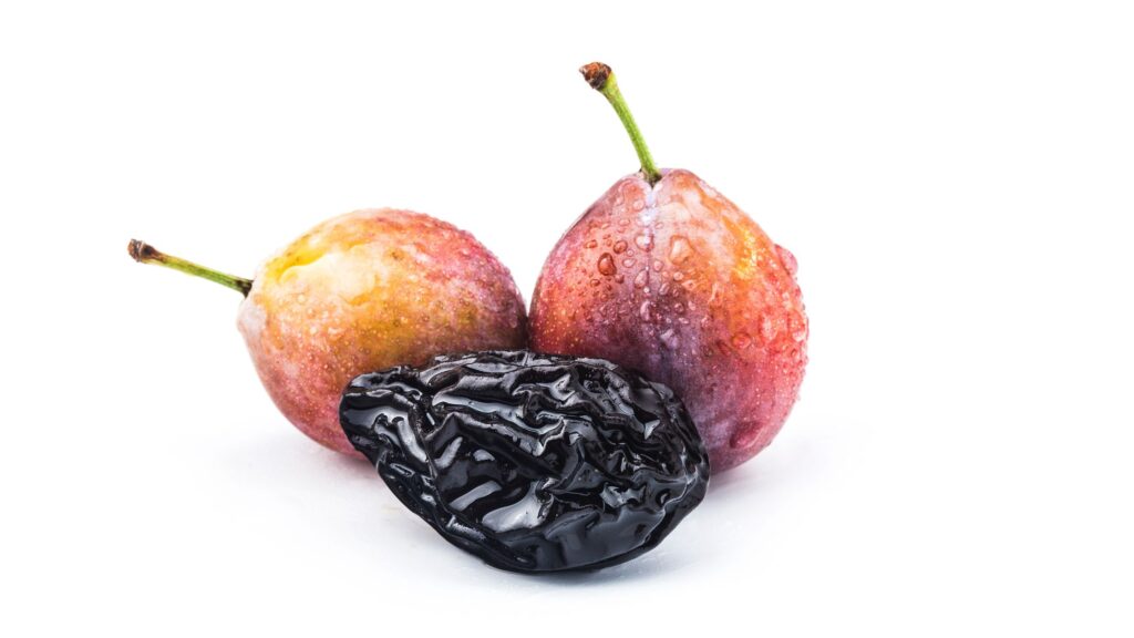 Dry prune and fresh prune is placed with the white background.