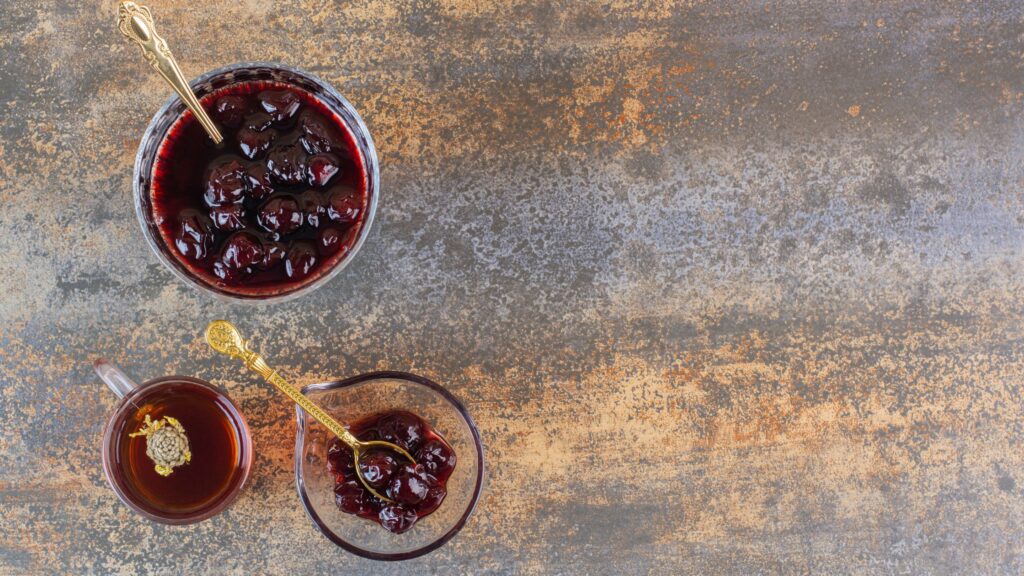 A jam made of fresh fruit is served in glass bowls.