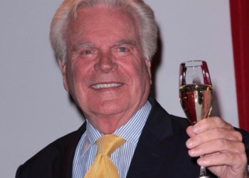 Robert Wagner holding a glass of wine in his hand.