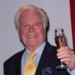 Robert Wagner holding a glass of wine in his hand.
