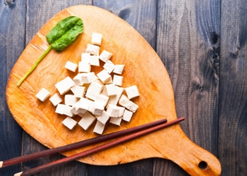 Raw Tofu on the wooden chopping board.