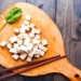 Raw Tofu on the wooden chopping board.