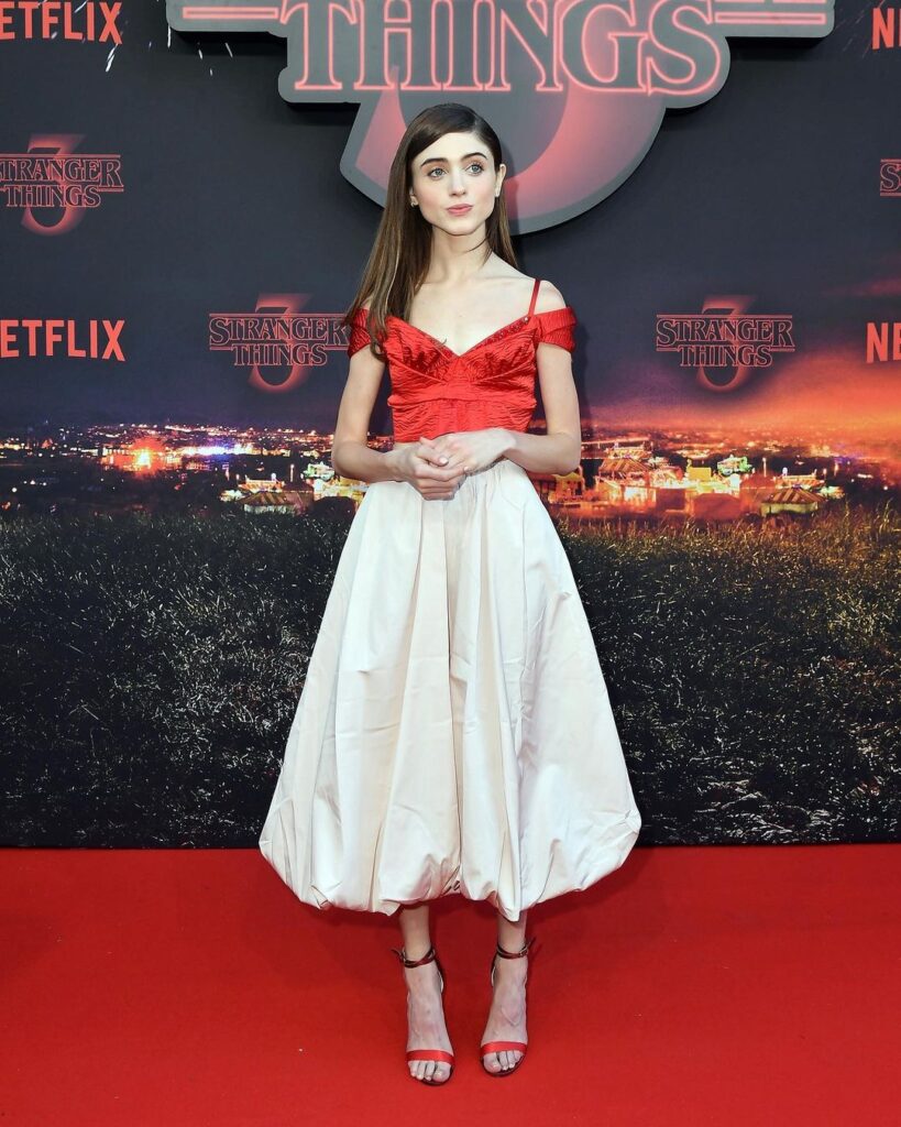 Natalia wearing red top and white skirt at the Paris premiere of Stranger Things
