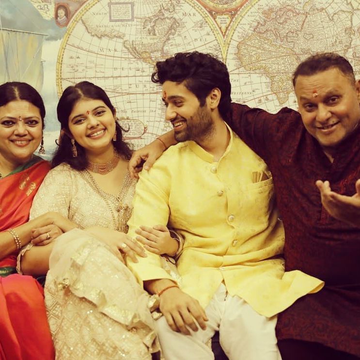 Family pic of Utkarsh. He is wearing a yellow kurta and posing with his mother, sister, and father.